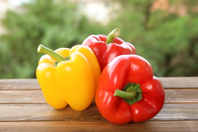 Raw ripe paprika peppers on table against blurred background