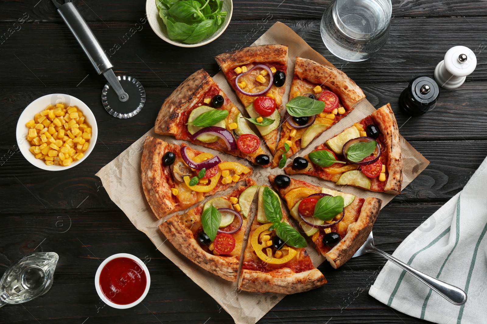 Photo of Flat lay composition with vegetable pizza on black wooden table