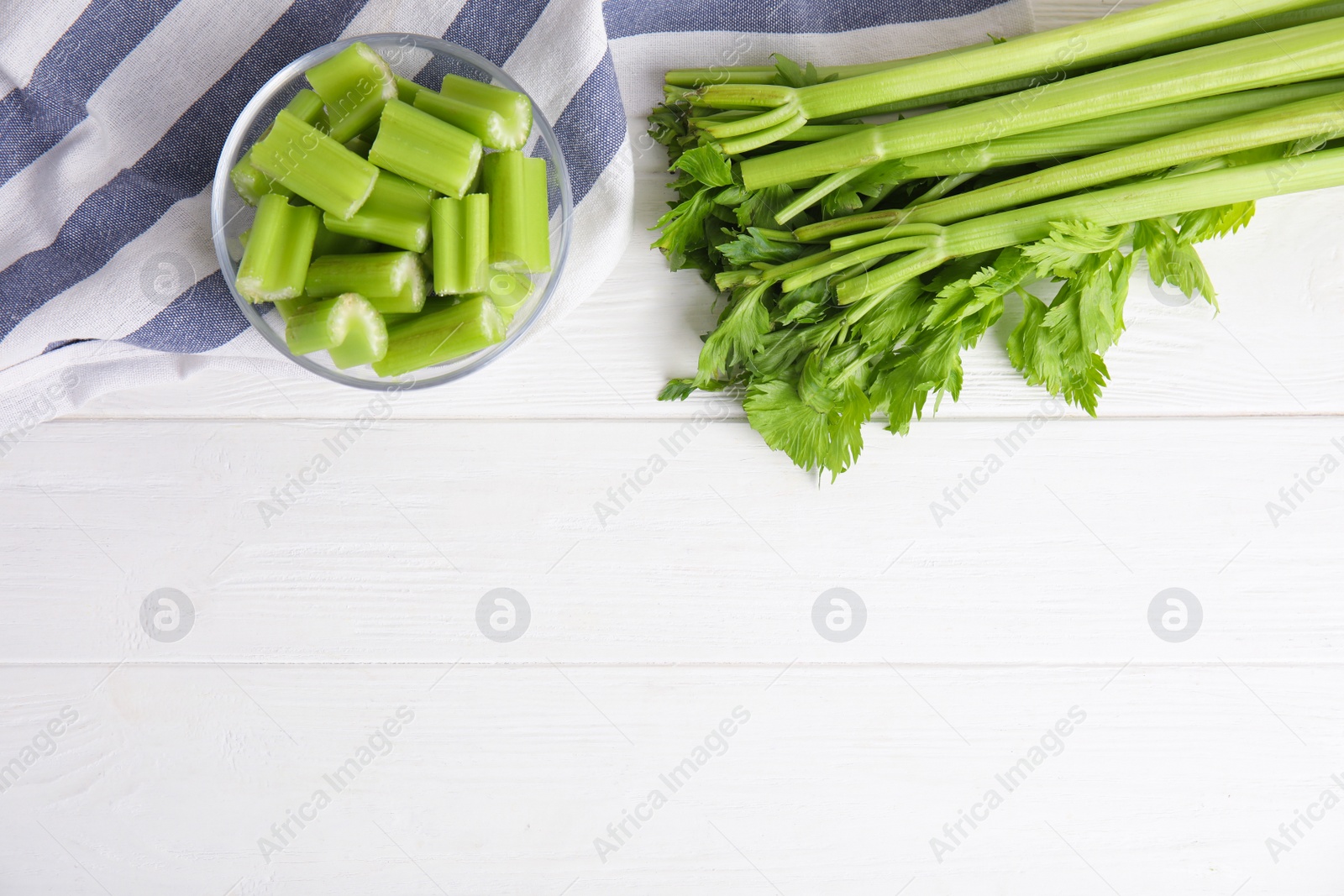 Photo of Fresh ripe green celery on white wooden table, flat lay. Space for text