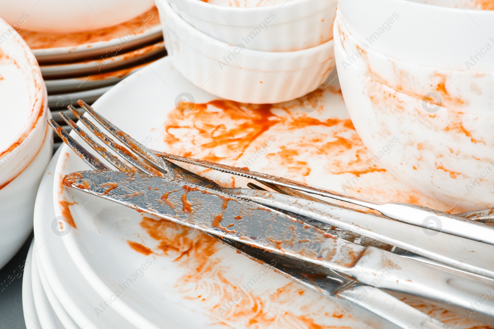 Photo of Stack of dirty dishes with cutlery, closeup