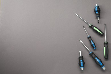 Photo of Set of screwdrivers on grey background, flat lay. Space for text