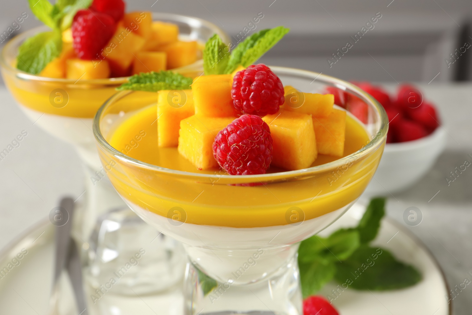 Photo of Delicious panna cotta with mango and raspberries, closeup