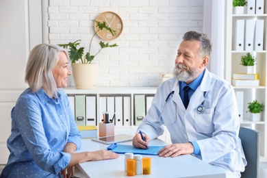 Photo of Mature doctor consulting patient in clinic