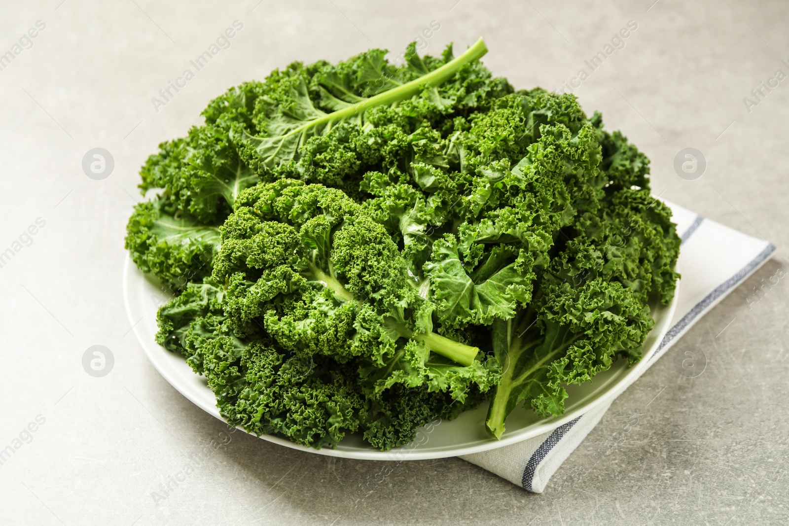 Photo of Fresh kale leaves on light grey table