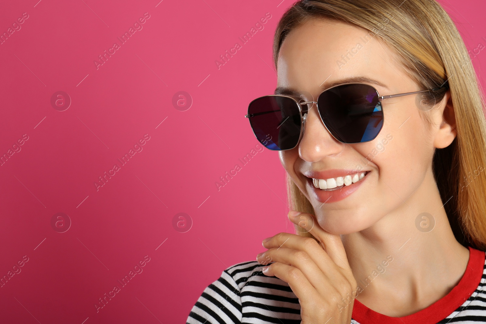 Photo of Beautiful woman in stylish sunglasses on pink background. Space for text