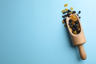 Photo of Scoop of raisins on color background, top view with space for text. Dried fruit as healthy snack