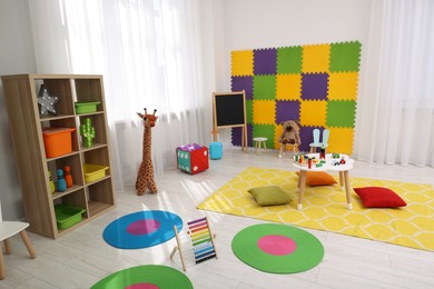 Child`s playroom with different toys and furniture. Cozy kindergarten interior