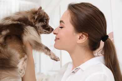 Happy young woman with cute dog at home