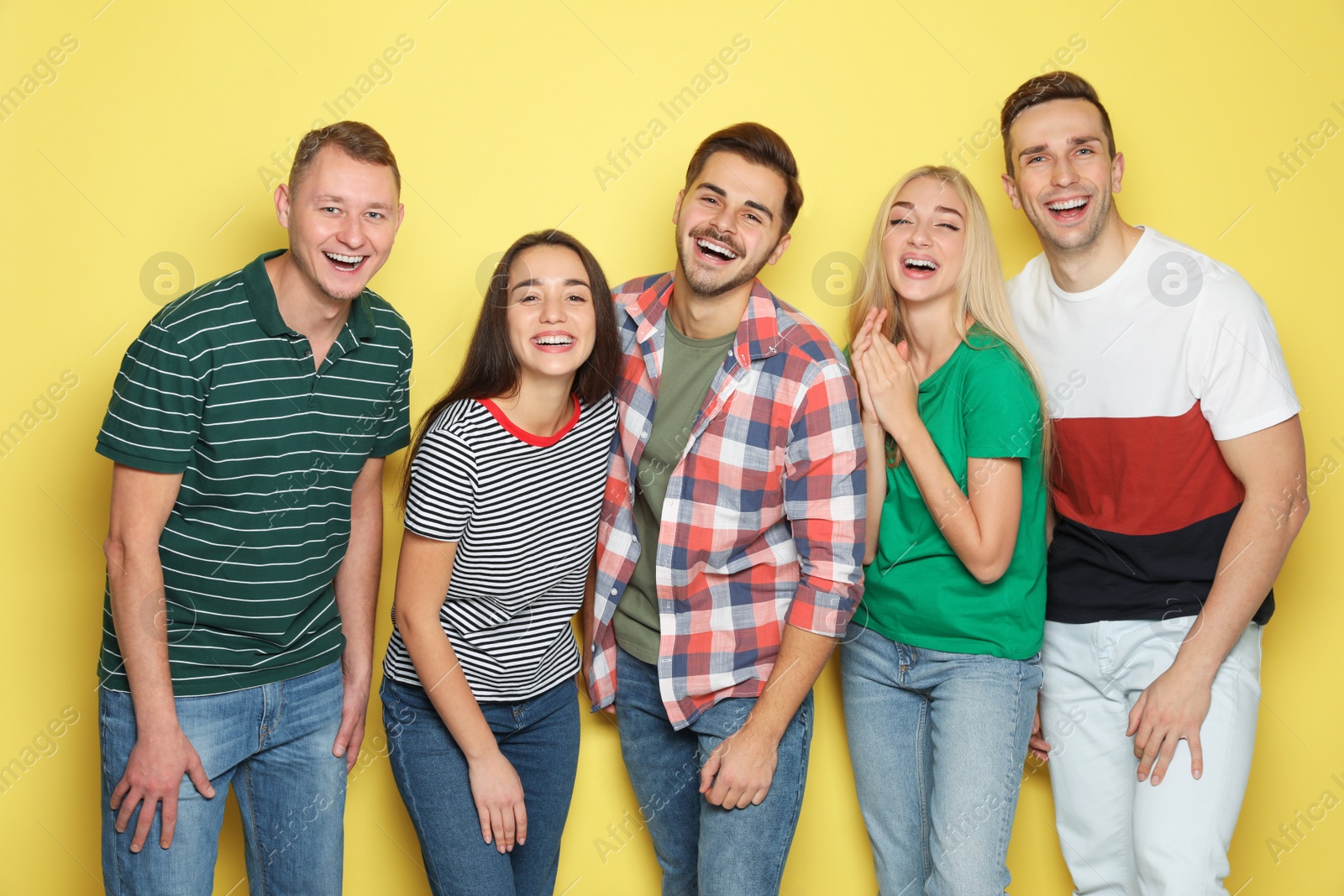 Photo of Group of friends laughing together against color background