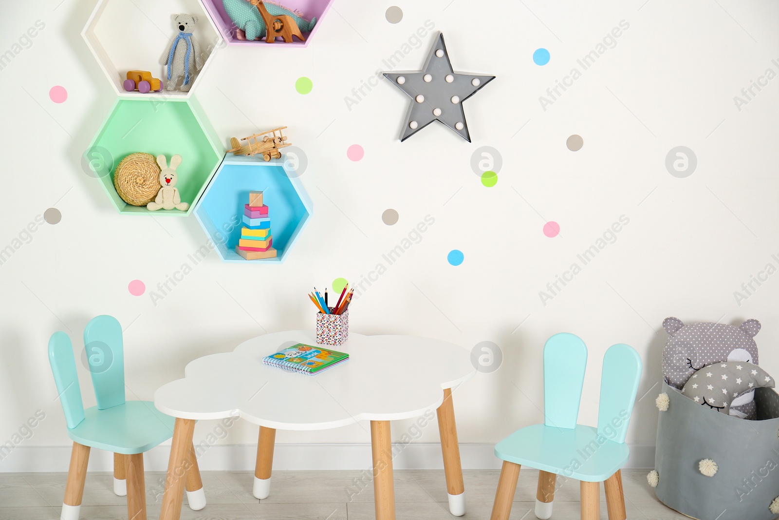 Photo of Bright colorful shelves on light wall in room. Interior design