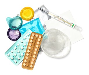 Photo of Contraceptive pills, condoms, patch and thermometer isolated on white, top view. Different birth control methods
