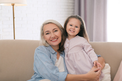 Photo of Happy granddaughter and grandmother together at home