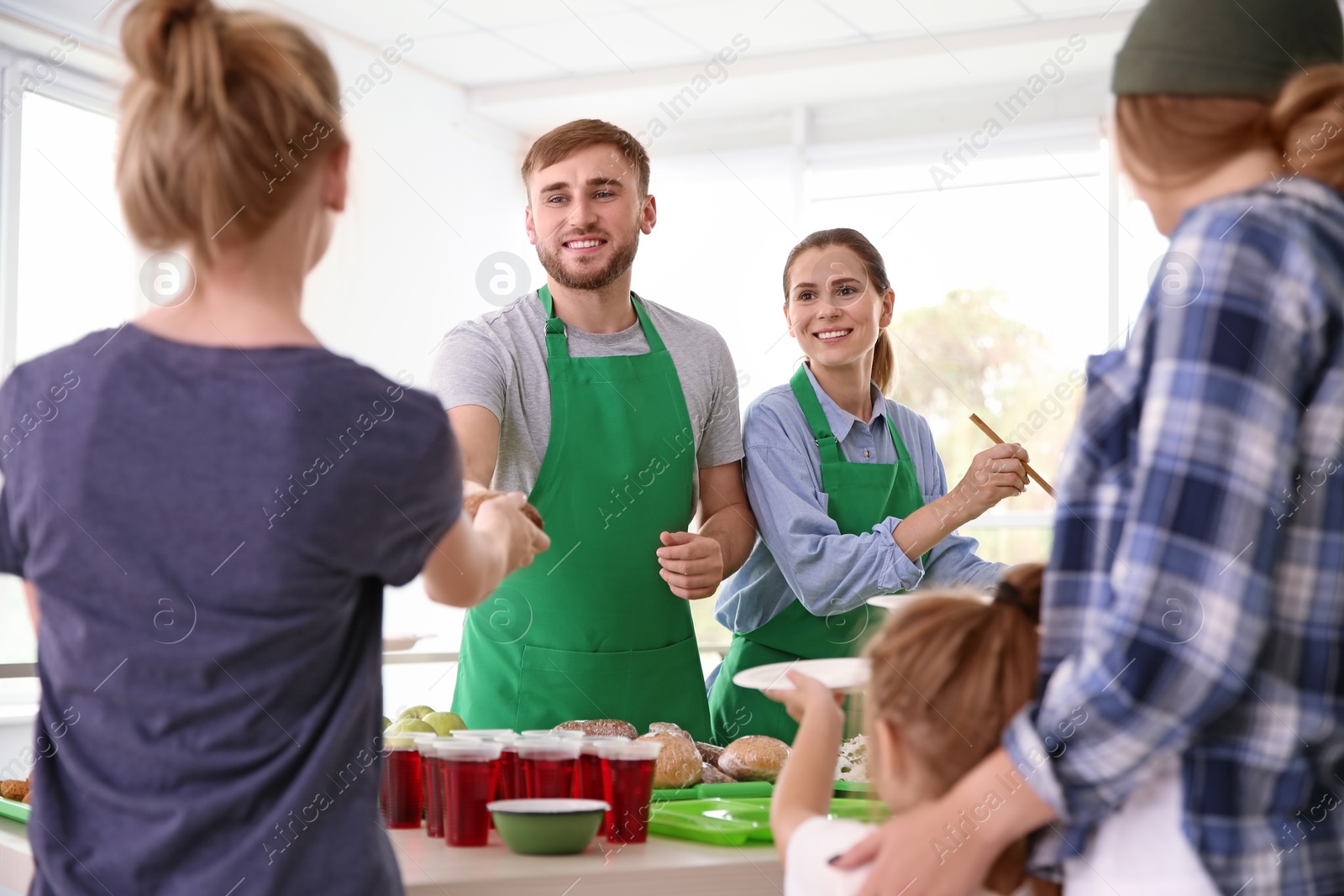 Photo of Volunteers serving food for poor people indoors