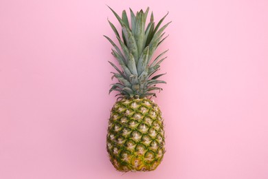 Whole ripe pineapple on pink background, top view