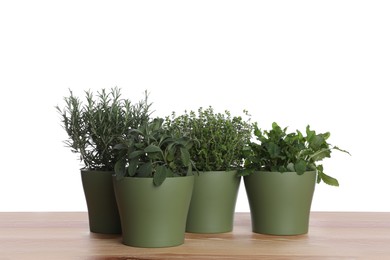 Photo of Pots with thyme, sage, mint and rosemary on wooden table against white background