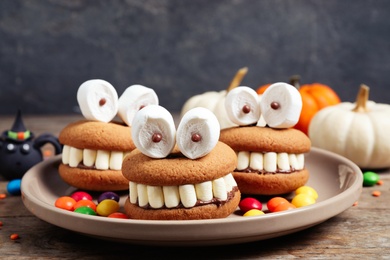 Delicious Halloween themed desserts on wooden table, closeup