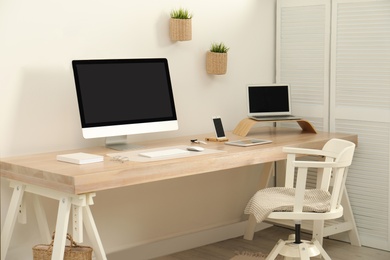 Stylish workplace interior with modern computer on table. Mockup for design