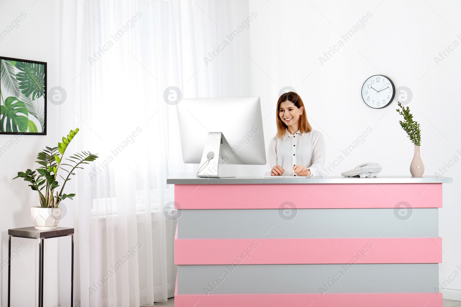 Photo of Beautiful woman working at reception desk in beauty salon