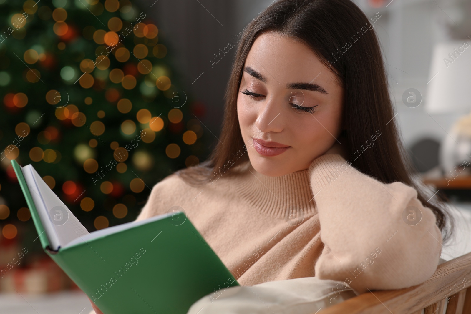 Photo of Christmas mood. Woman reading book in room