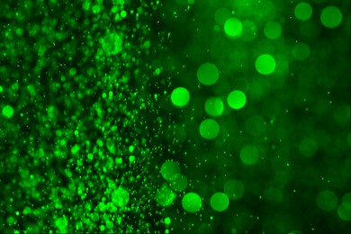 Image of St. Patrick day. Shiny green glitter on black background, bokeh effect