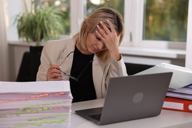 Overwhelmed woman sitting at table in office