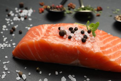 Fresh salmon and ingredients for marinade on black table, closeup