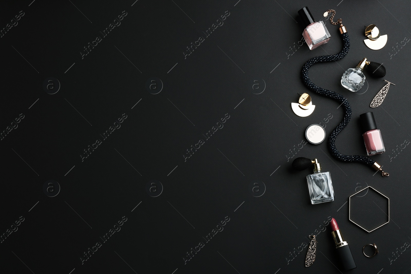 Photo of Composition with perfume bottles, cosmetics and jewellery on black background, flat lay. Space for text