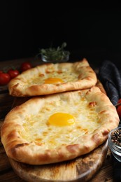 Photo of Fresh delicious Adjarian khachapuris served on wooden table
