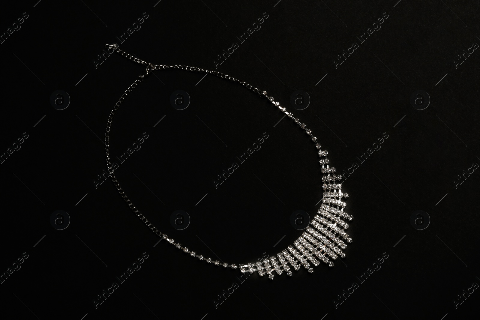 Photo of Stylish necklace with gemstones on black background, top view. Luxury jewelry