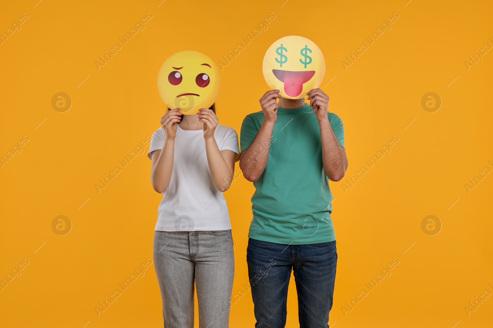 Photo of People covering faces with emoticons on yellow background