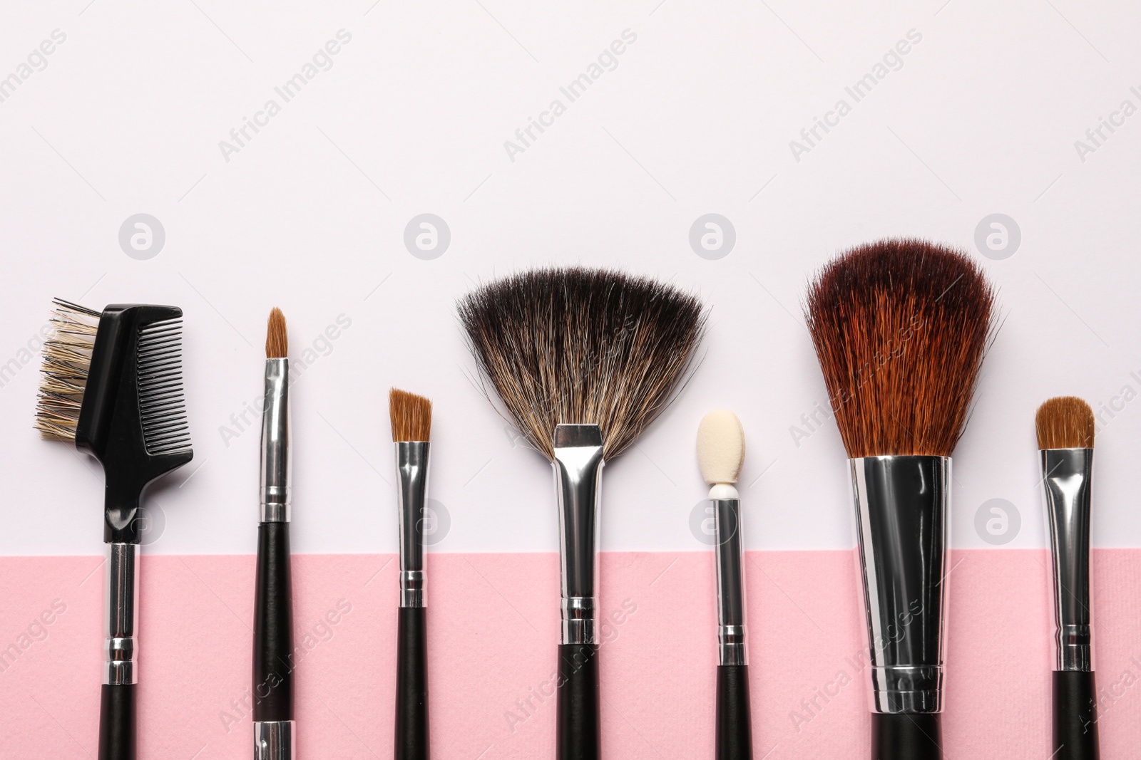 Photo of Different makeup brushes on color background, flat lay