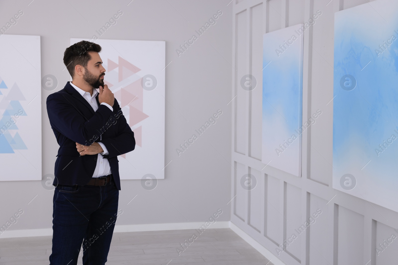 Photo of Thoughtful young man at exhibition in art gallery