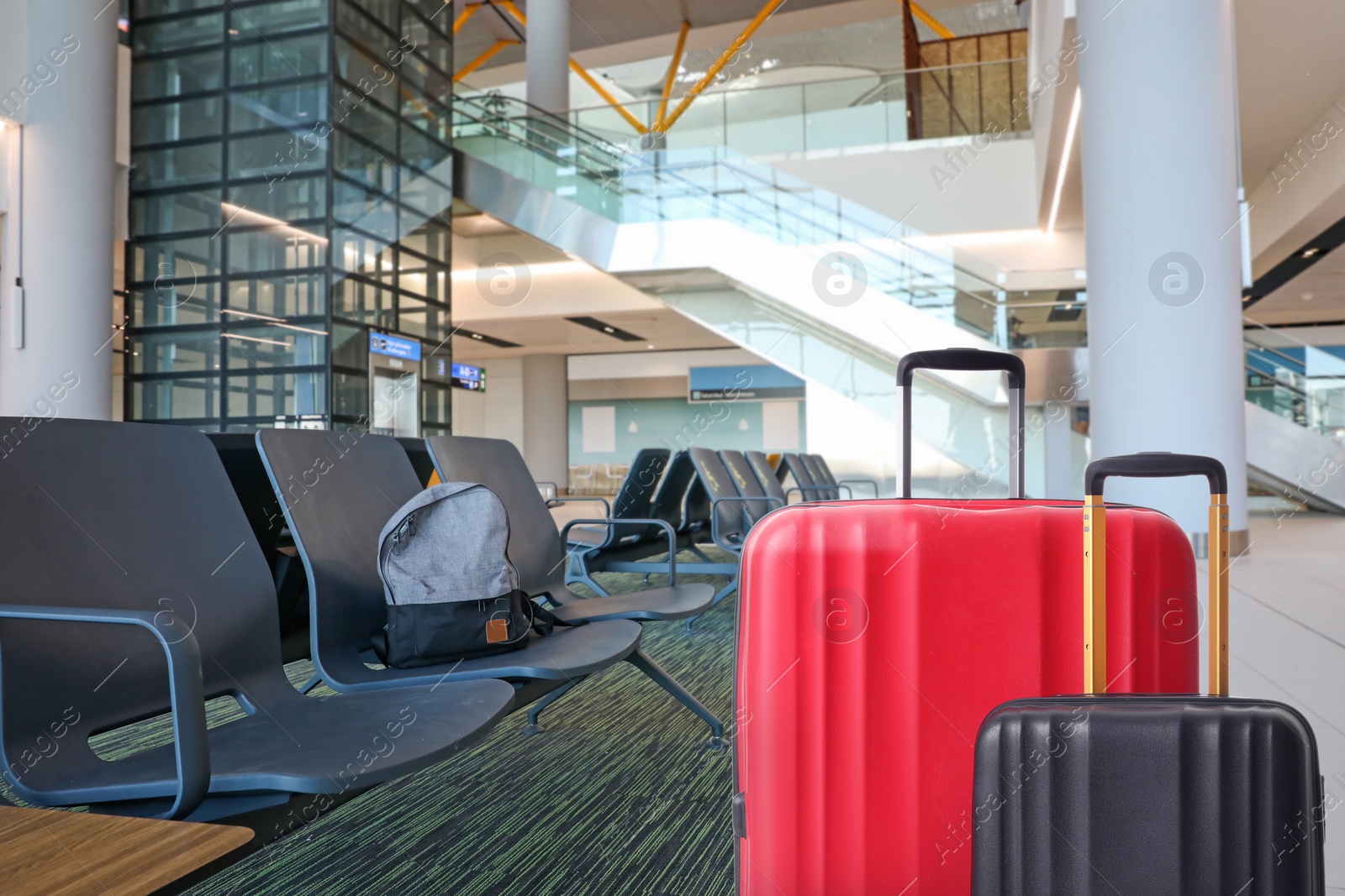 Image of Stylish suitcases in waiting area at airport terminal