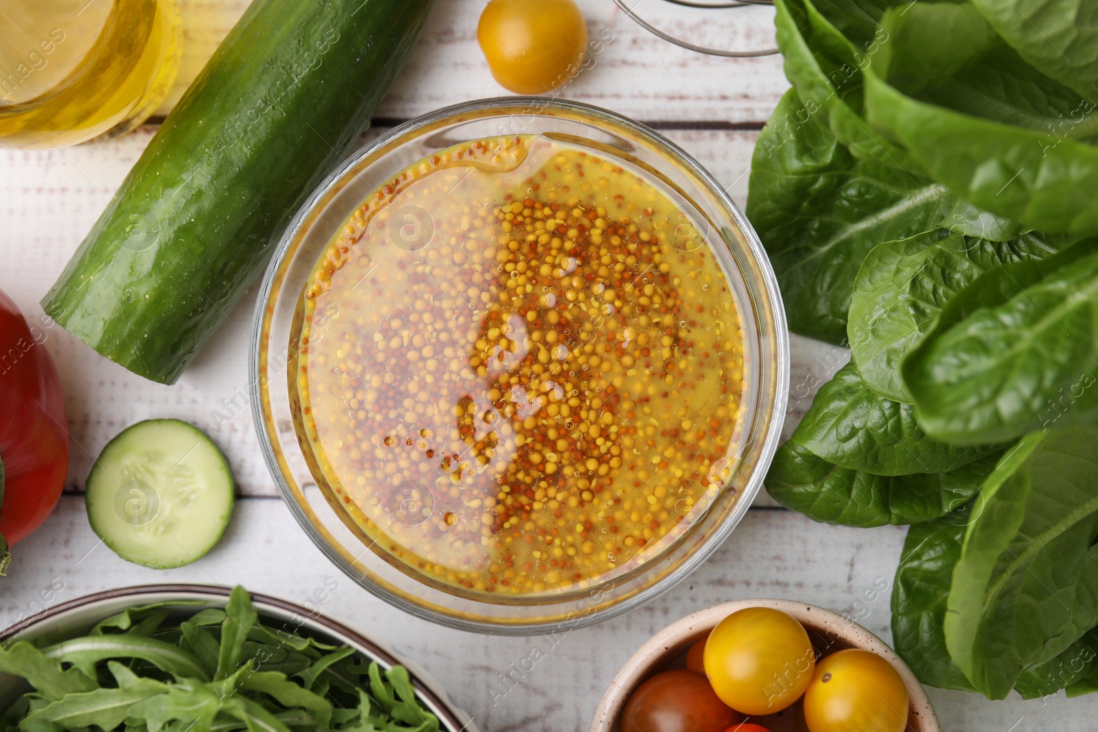 Photo of Tasty vinegar based sauce (Vinaigrette) in bowl and products on wooden rustic table, flat lay