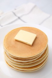 Photo of Delicious pancakes with butter on table, closeup