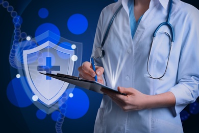 Image of Immunologist and shield with cross as symbol of virus protection on blue background, closeup