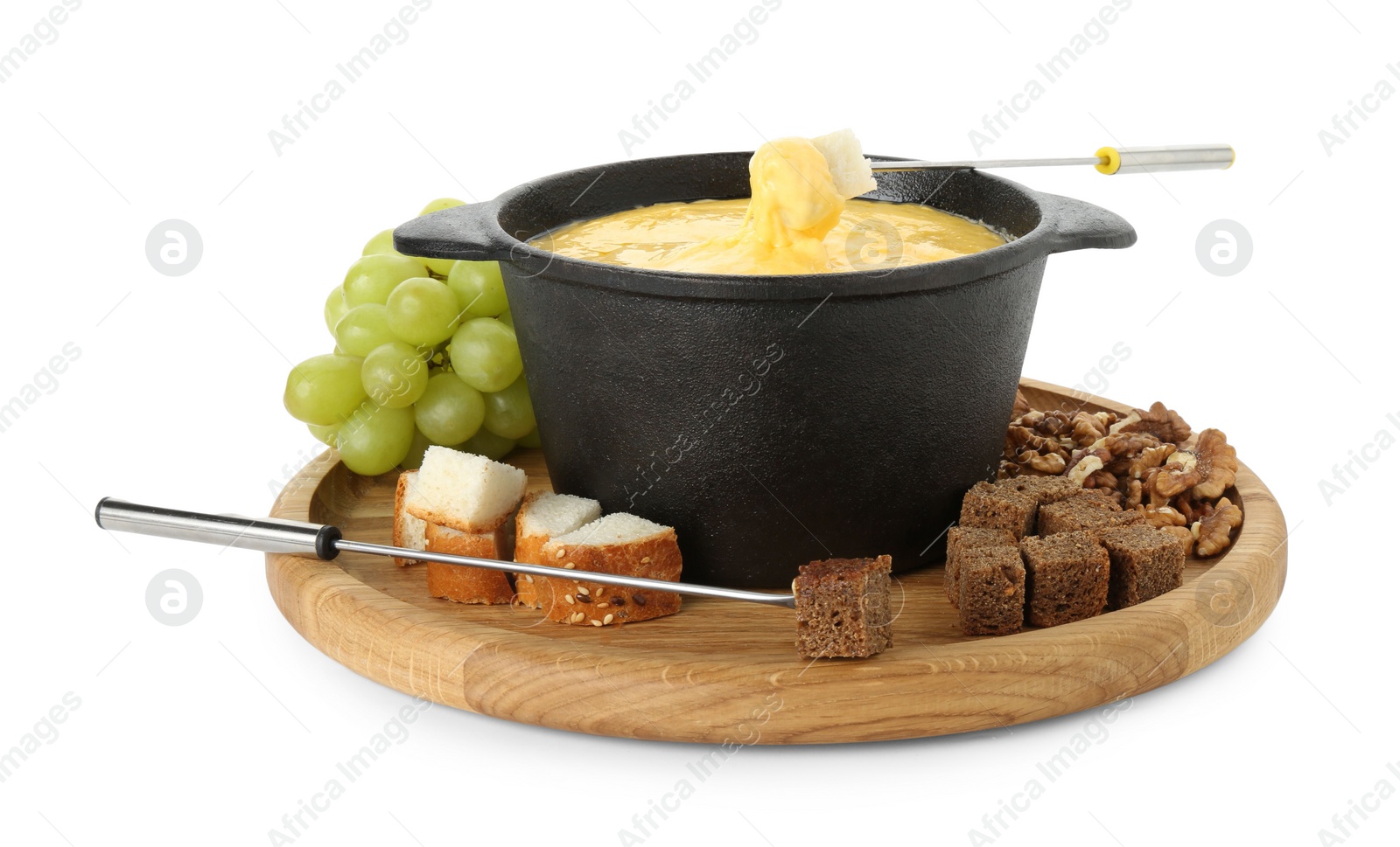 Photo of Fondue with tasty melted cheese, forks, grapes and pieces of bread isolated on white
