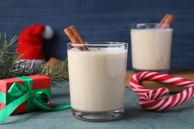 Delicious Christmas liqueur on blue wooden table, closeup