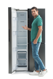 Photo of Man near empty refrigerator on white background