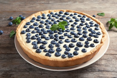 Tasty cake with blueberry on wooden table