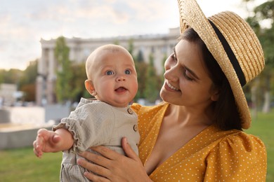 Photo of Happy mother with adorable baby walking on sunny day