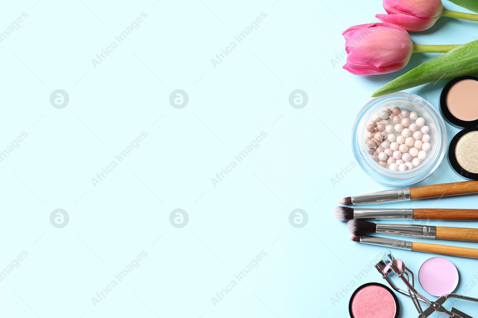 Photo of Makeup products and flowers on color background, flat lay with space for text