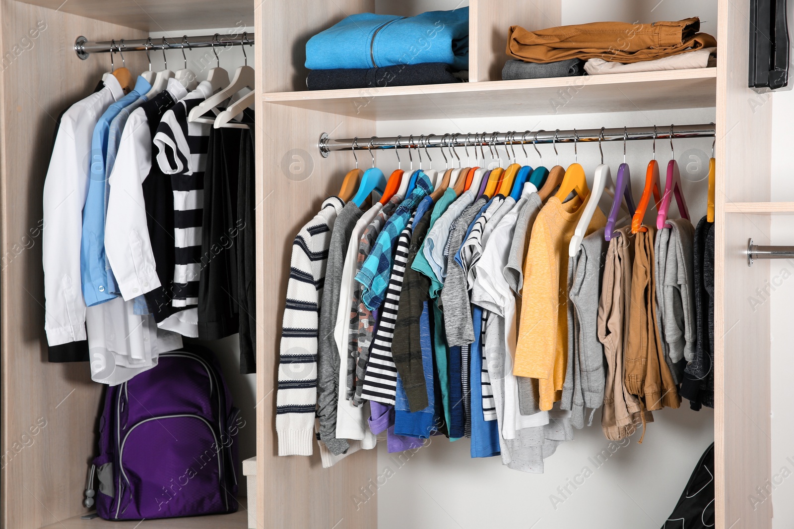 Photo of Wardrobe with stylish boy's clothes hanging on rack