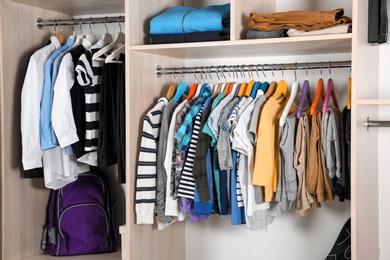 Wardrobe with stylish boy's clothes hanging on rack