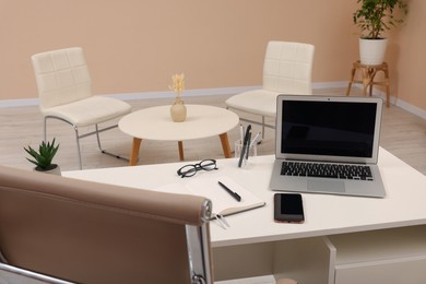 Photo of Cozy receptionist workspace with laptop on desk in office