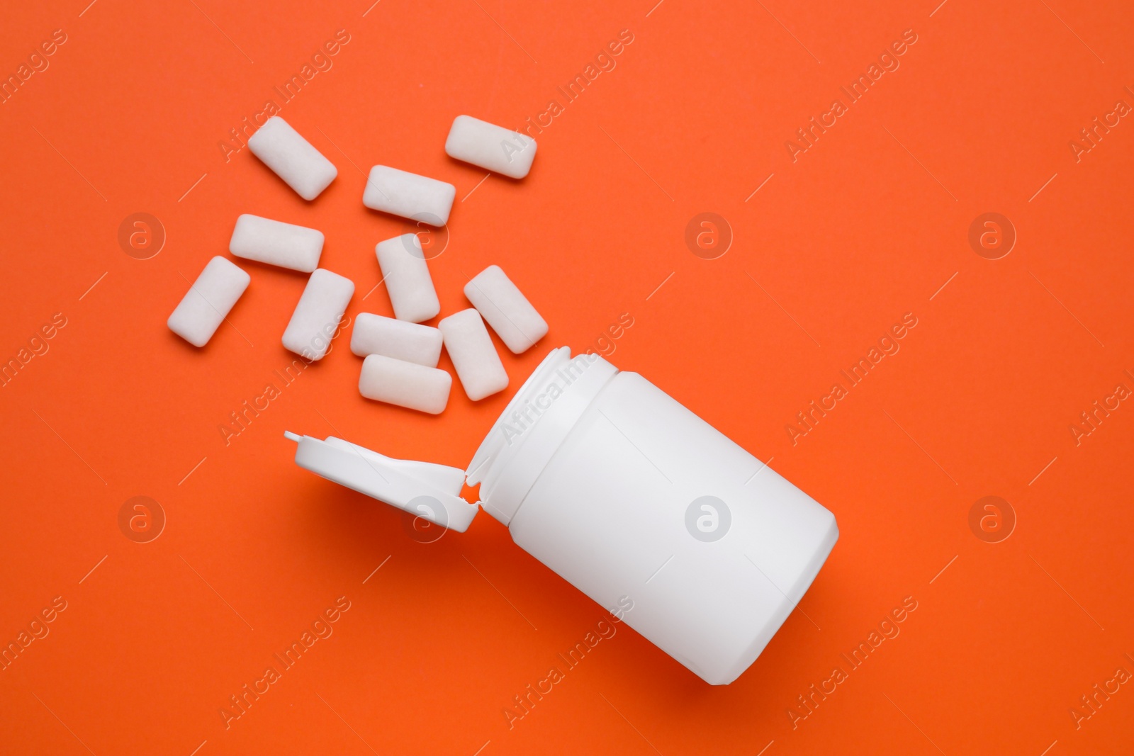 Photo of Jar with chewing gums on orange background, flat lay