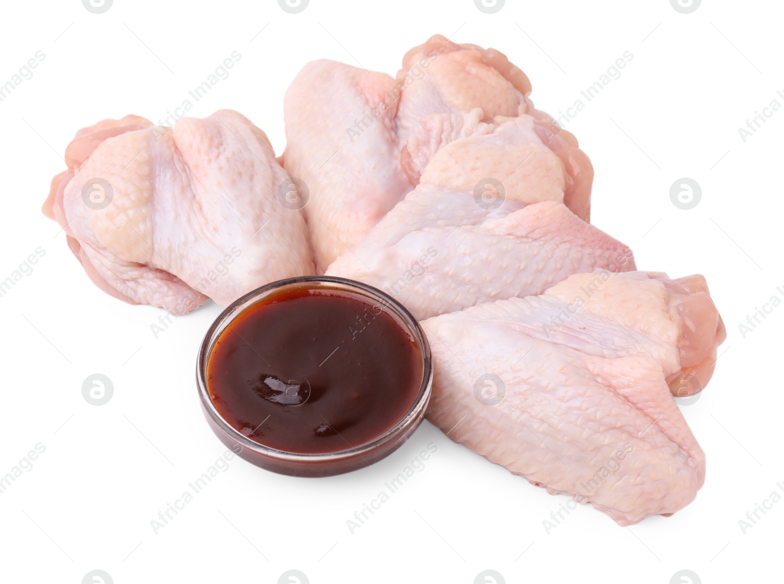 Photo of Fresh marinade and raw chicken wings isolated on white