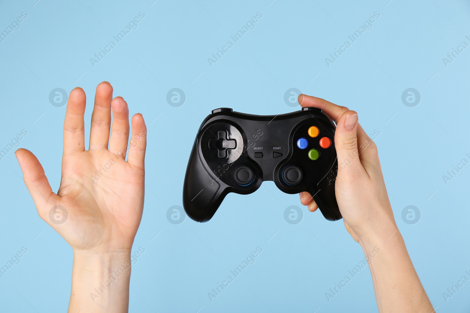 Photo of Woman with game controller on light blue background, closeup