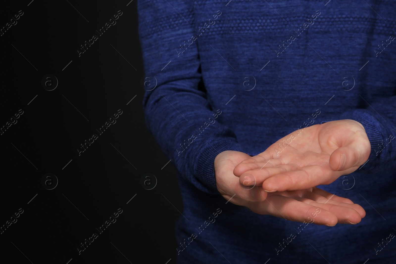 Photo of Man showing word GOOD in sign language on black background, closeup. Space for text