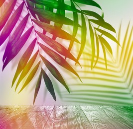 Image of Palm branches and wooden table against light background, color tone effect. Summer party
